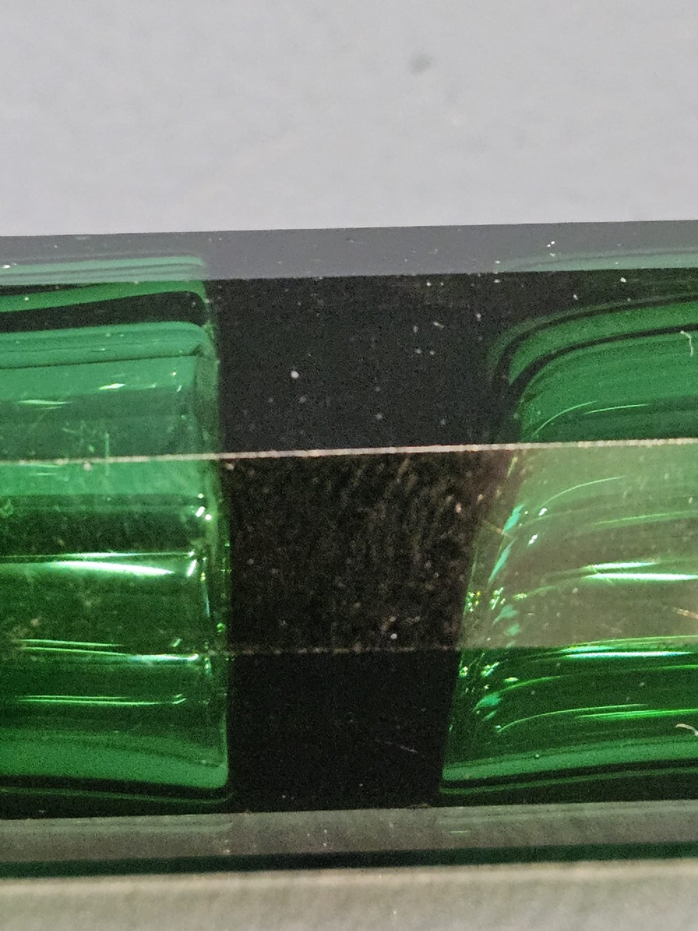 A Victorian double-ended emerald green facet-cut glass scent bottle with detailed embossed silver caps on both ends. View IV