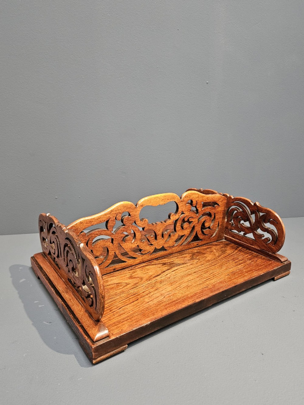 An antique Regency rosewood book carrier featuring openwork scroll-carved galleries and a central top handle.