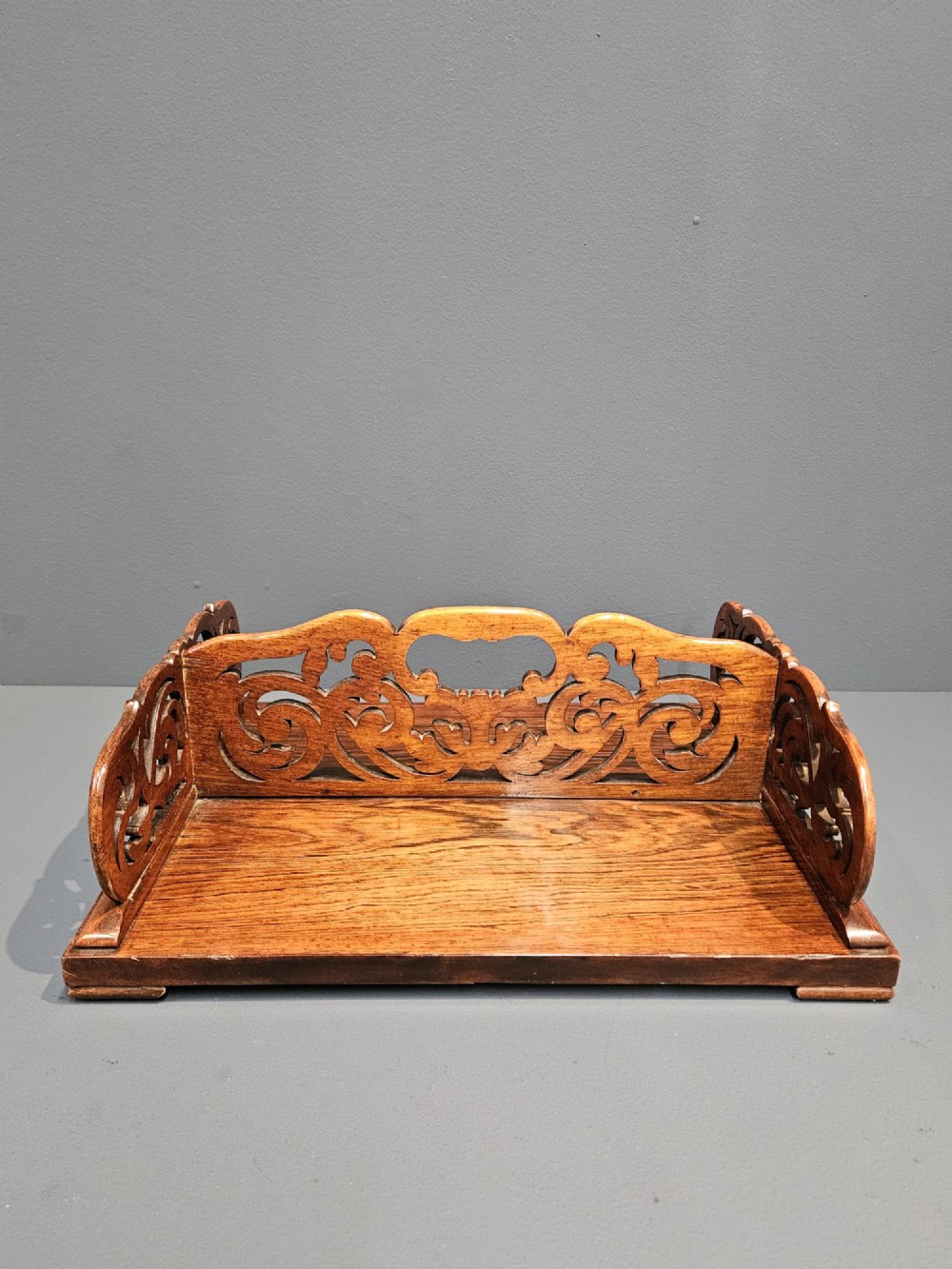 An antique Regency rosewood book carrier featuring openwork scroll-carved galleries and a central top handle. View IV