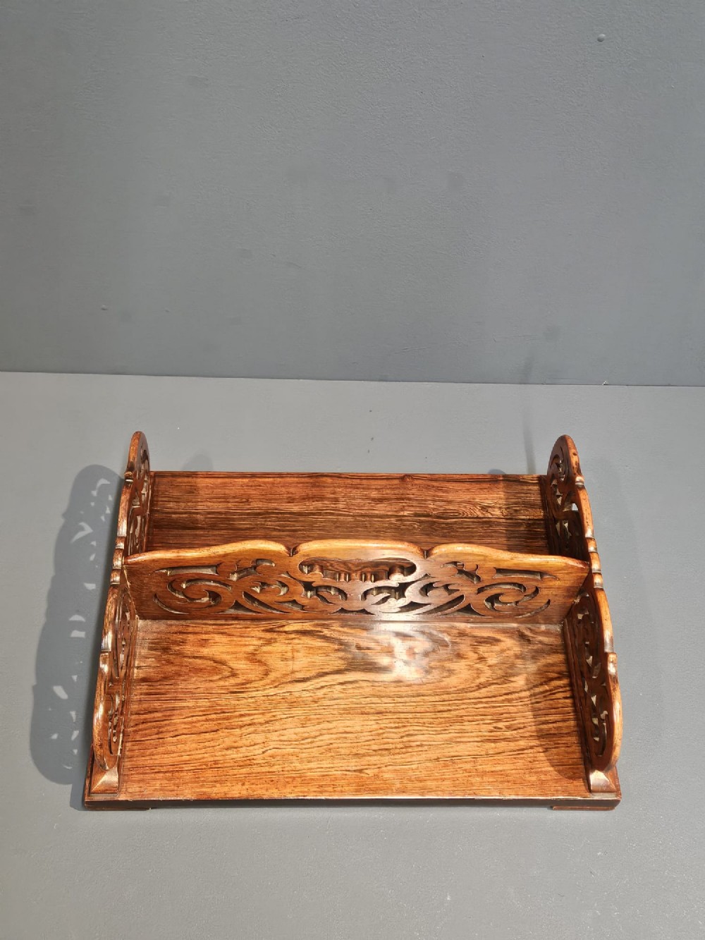 An antique Regency rosewood book carrier featuring openwork scroll-carved galleries and a central top handle. View V