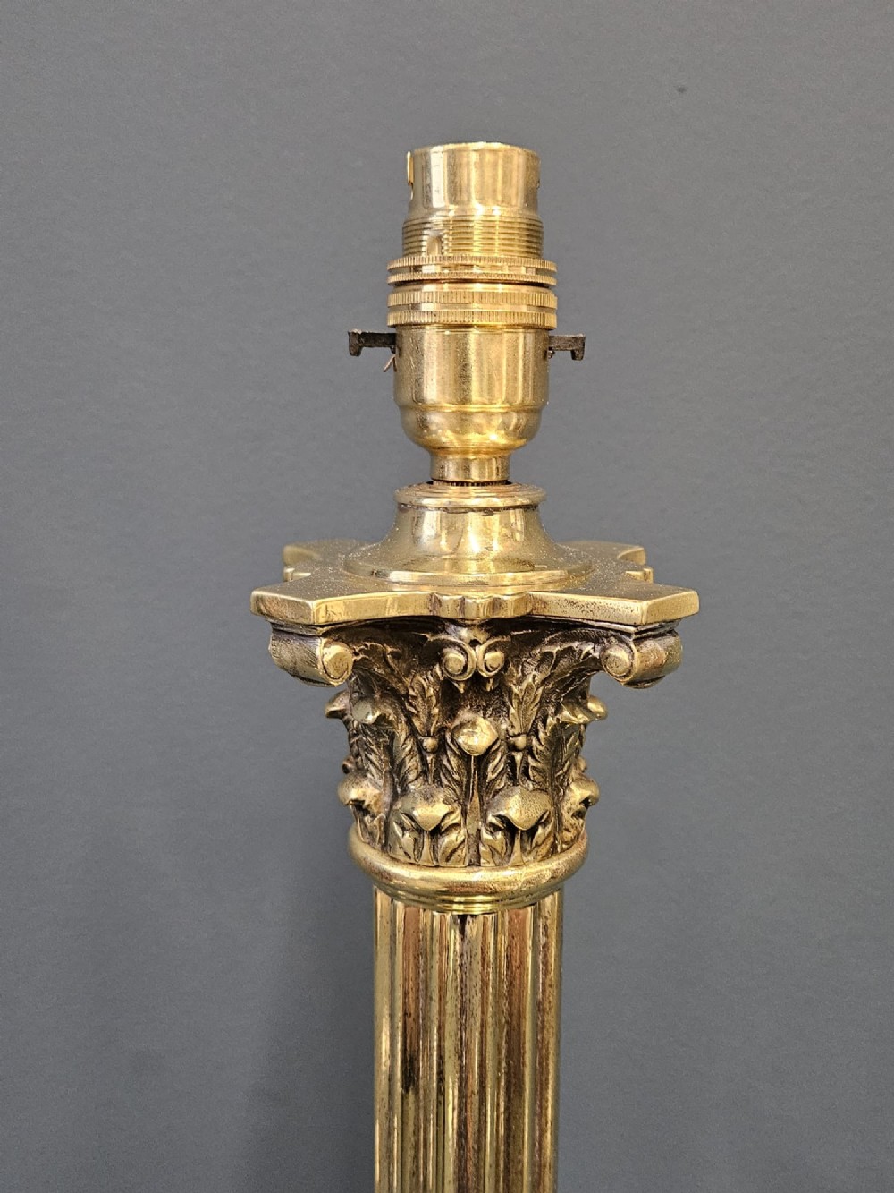A brass table lamp base designed as a fluted Corinthian column on a square stepped pedestal base. View III