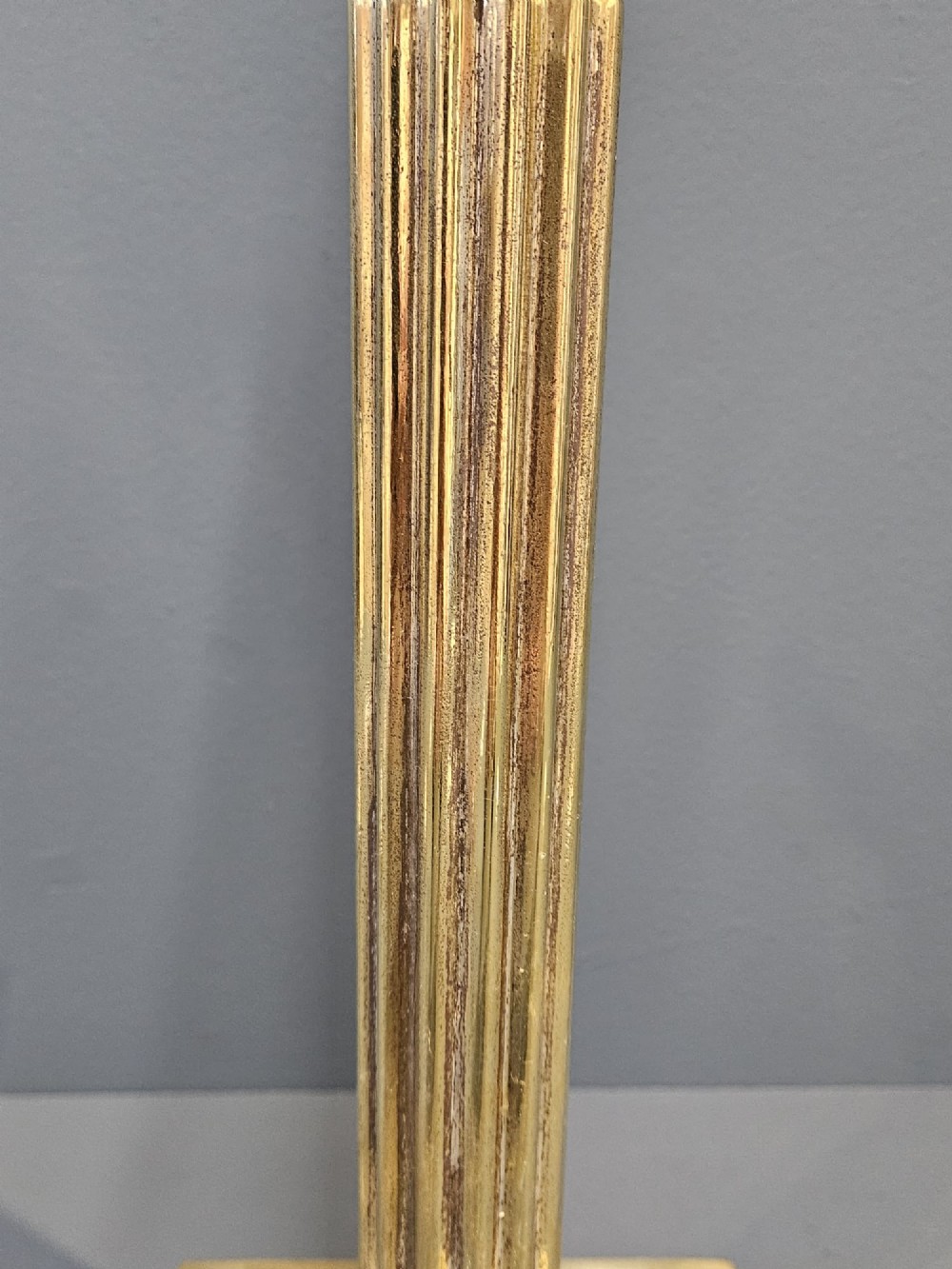 A brass table lamp base designed as a fluted Corinthian column on a square stepped pedestal base. View IV