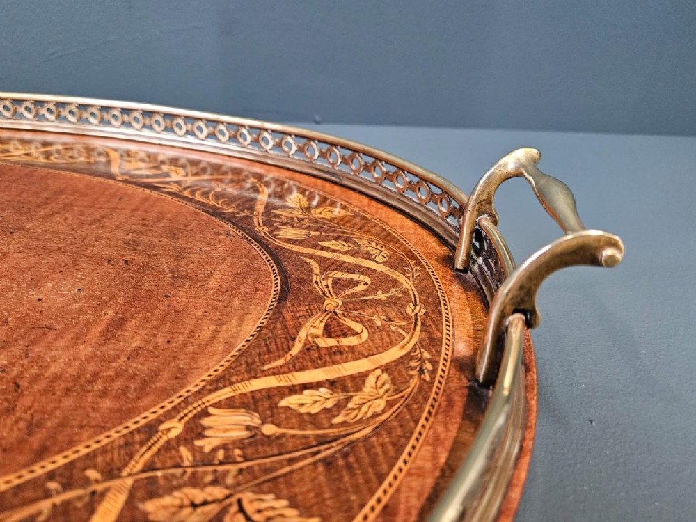 An oval Victorian mahogany serving tray featuring detailed floral marquetry inlay, a central shell motif, and a pierced brass gallery rim with two handles. View IV
