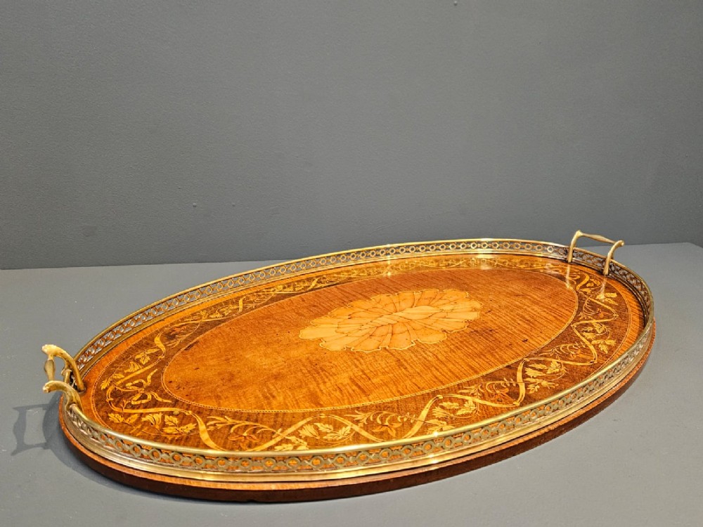 An oval Victorian mahogany serving tray featuring detailed floral marquetry inlay, a central shell motif, and a pierced brass gallery rim with two handles. View VII