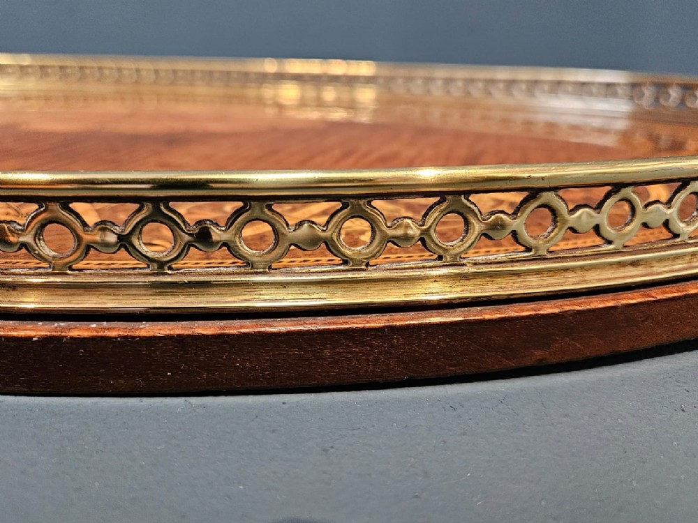 An oval Victorian mahogany serving tray featuring detailed floral marquetry inlay, a central shell motif, and a pierced brass gallery rim with two handles. View VIII