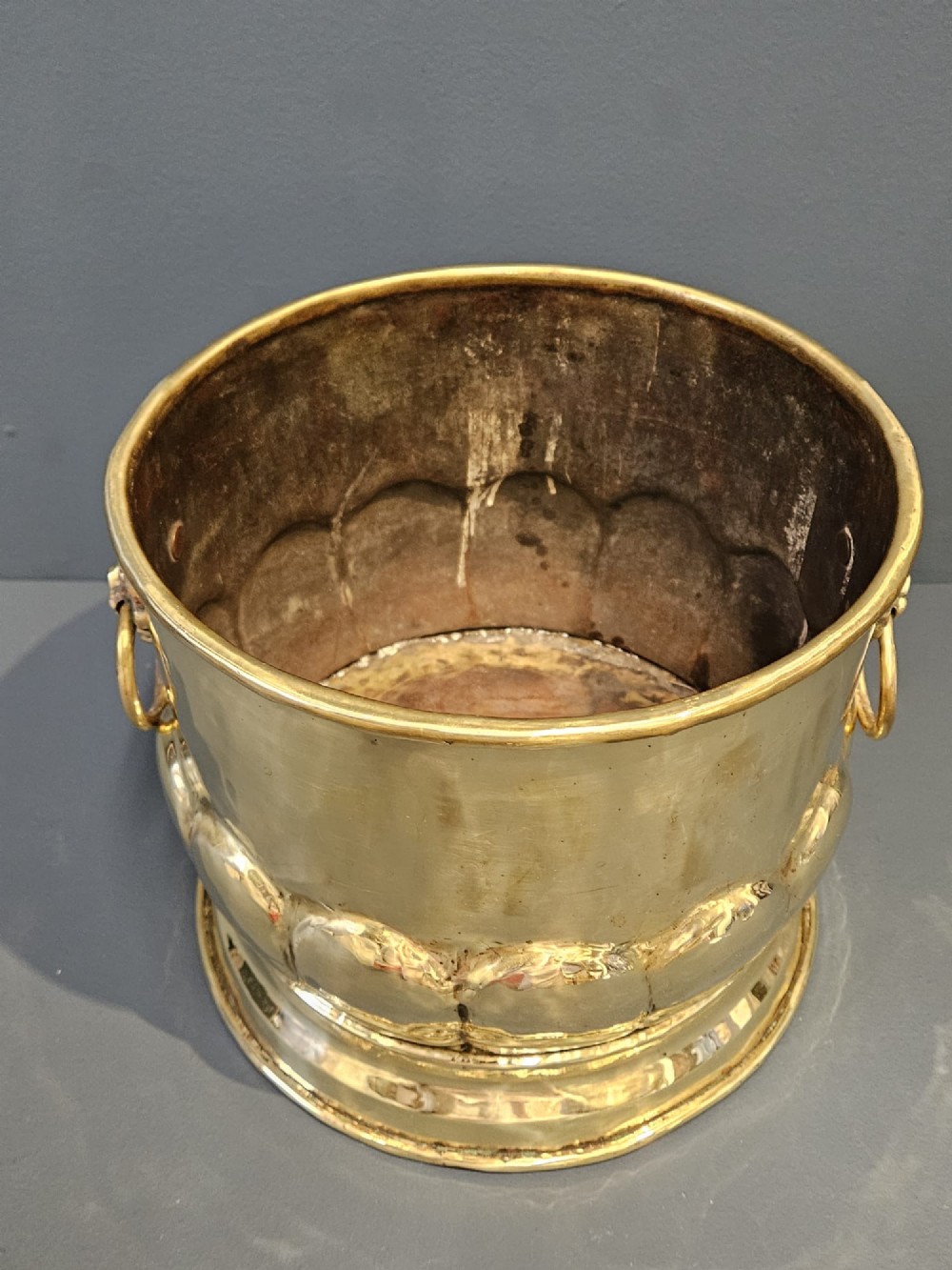 A Victorian brass planter featuring a polished finish, lobed lower body, and cast lion mask ring handles. View IV
