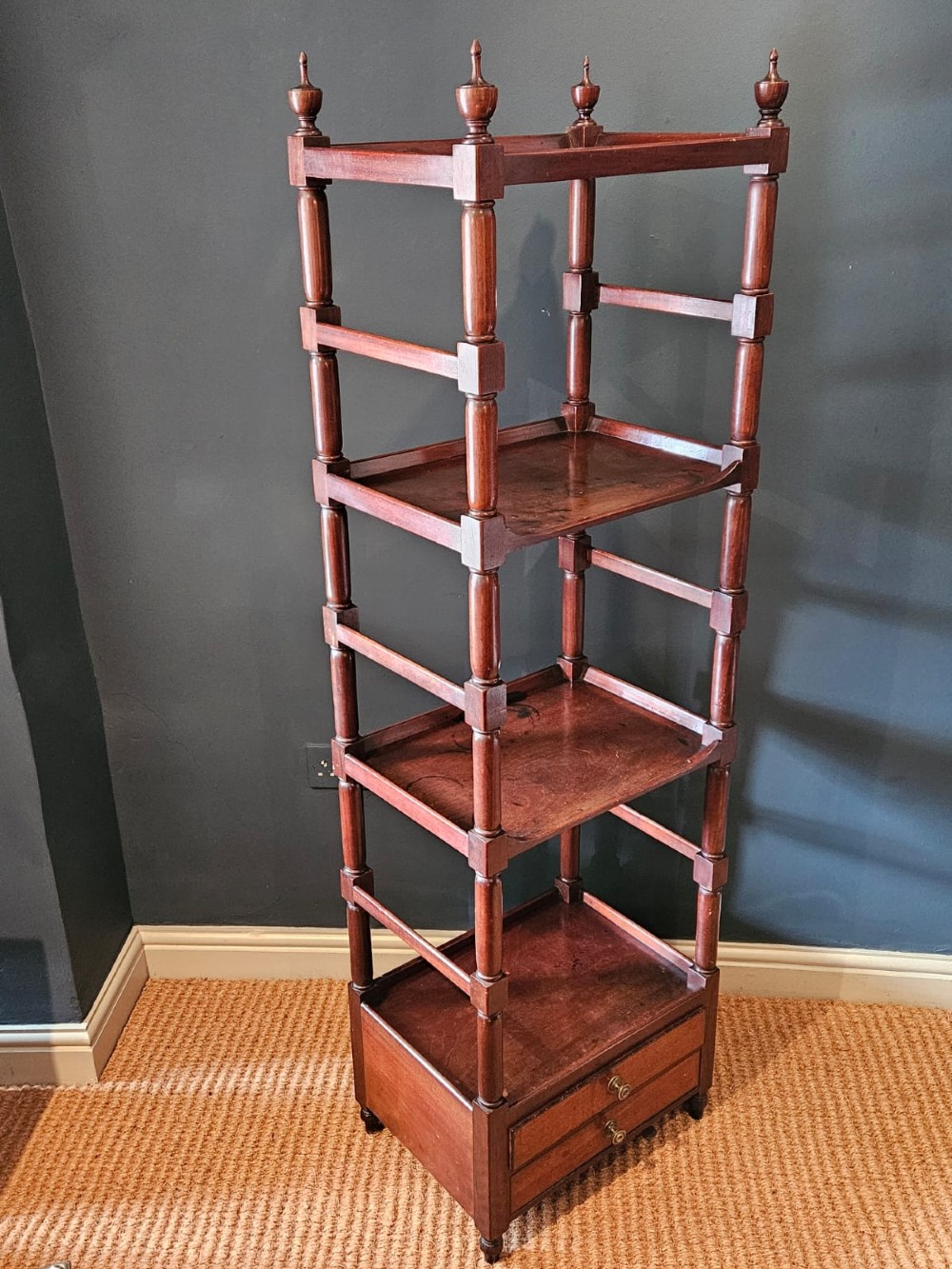 A tall Regency four-tier mahogany whatnot stand with slender turned posts, finial top ornaments, open shelves, and a base drawer. View IX