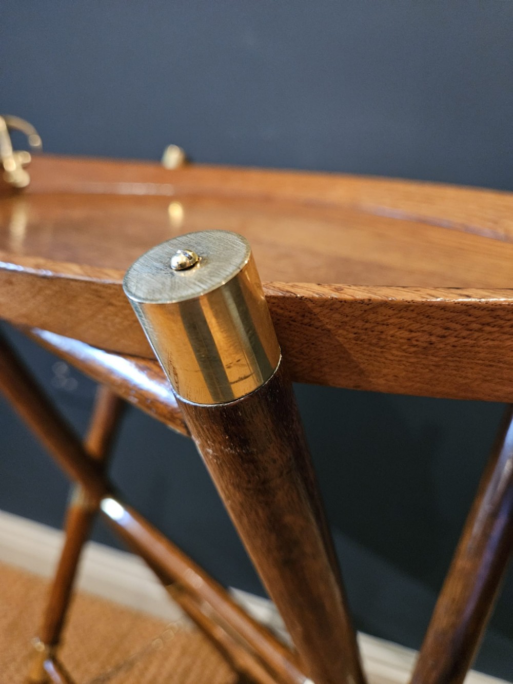 A boat-shaped oak tray with brass handles resting on a folding wooden stand constructed from crossed oars. View V