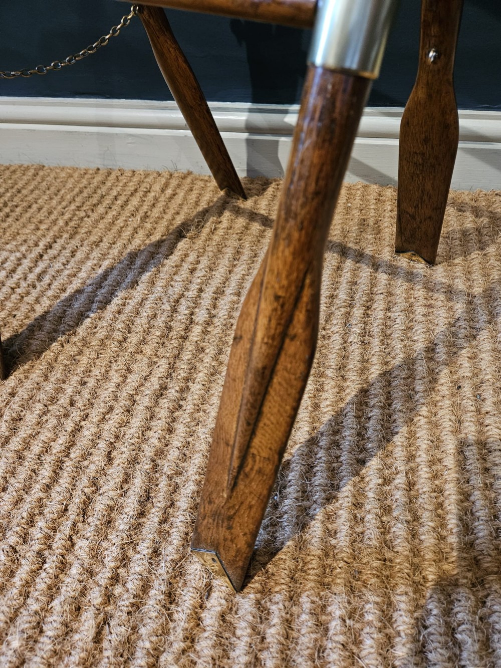 A boat-shaped oak tray with brass handles resting on a folding wooden stand constructed from crossed oars. View VII