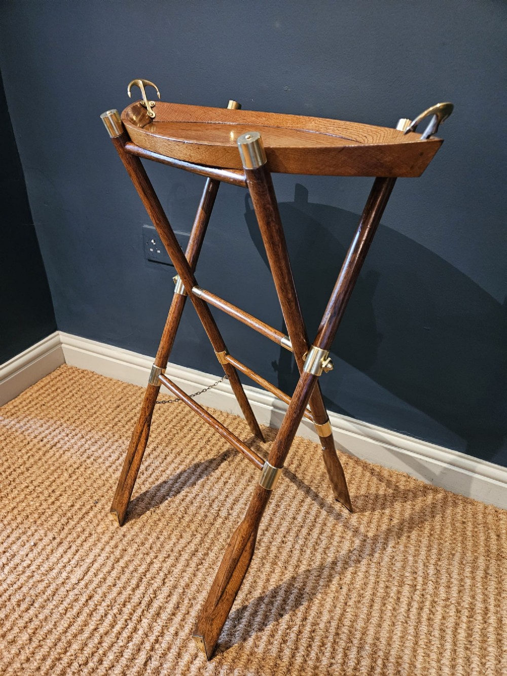 A boat-shaped oak tray with brass handles resting on a folding wooden stand constructed from crossed oars. View VIII