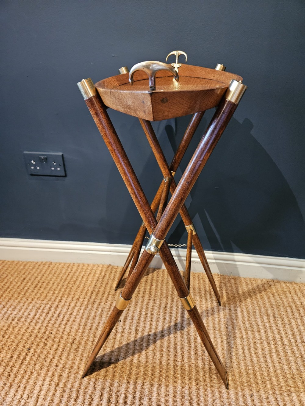 A boat-shaped oak tray with brass handles resting on a folding wooden stand constructed from crossed oars. View IX