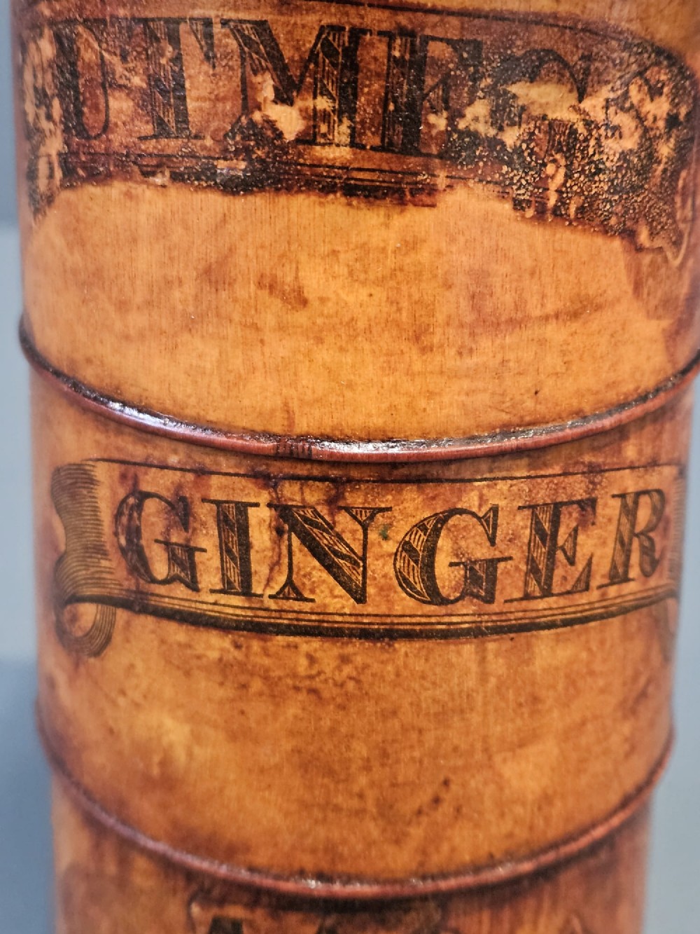 A cylindrical turned fruitwood spice tower featuring stacked compartments labelled Nutmeg, Ginger, and Mace. View III