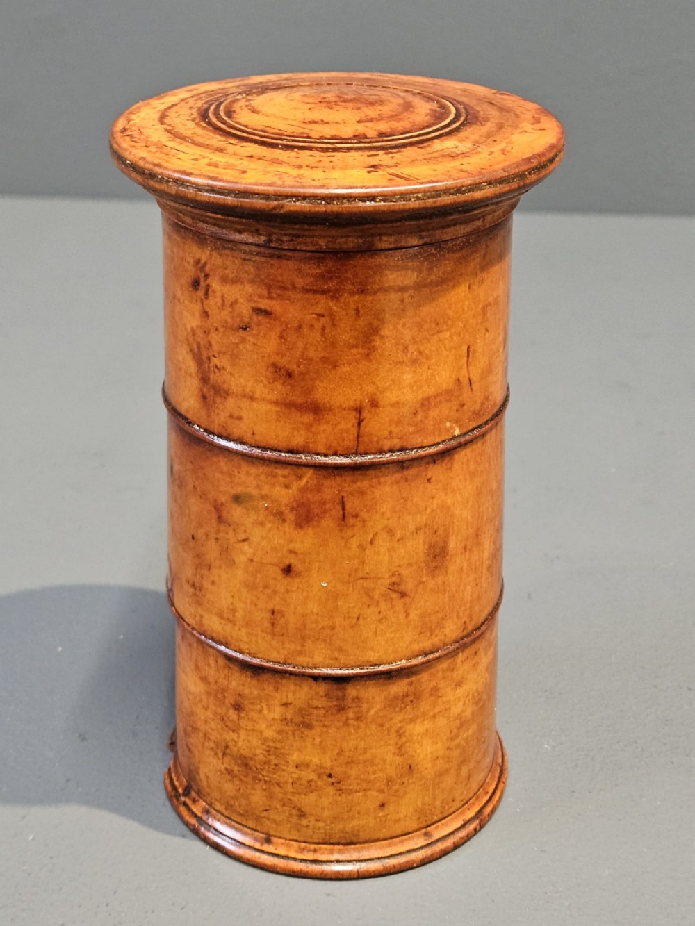 A cylindrical turned fruitwood spice tower featuring stacked compartments labelled Nutmeg, Ginger, and Mace. View IV