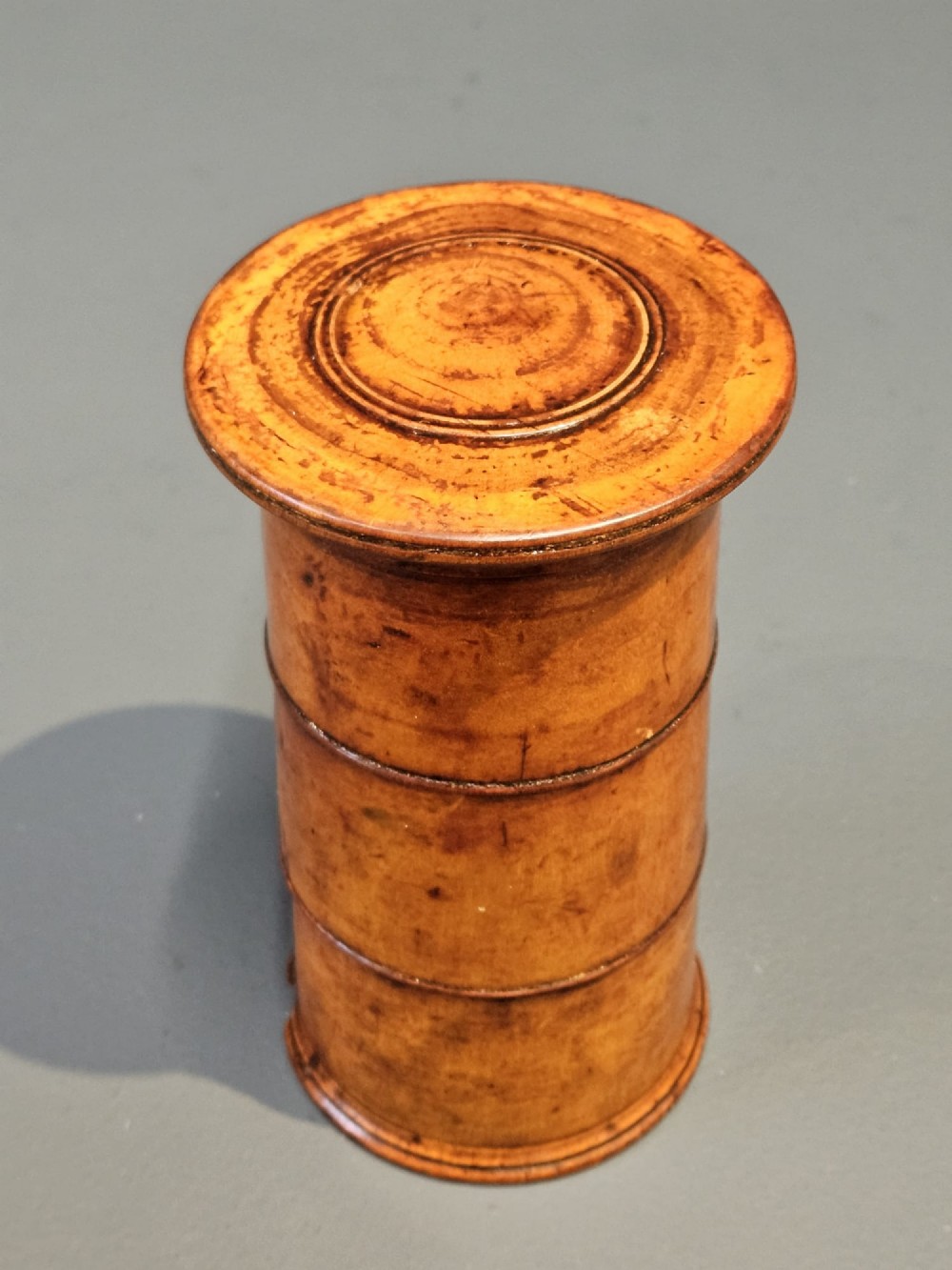 A cylindrical turned fruitwood spice tower featuring stacked compartments labelled Nutmeg, Ginger, and Mace. View V