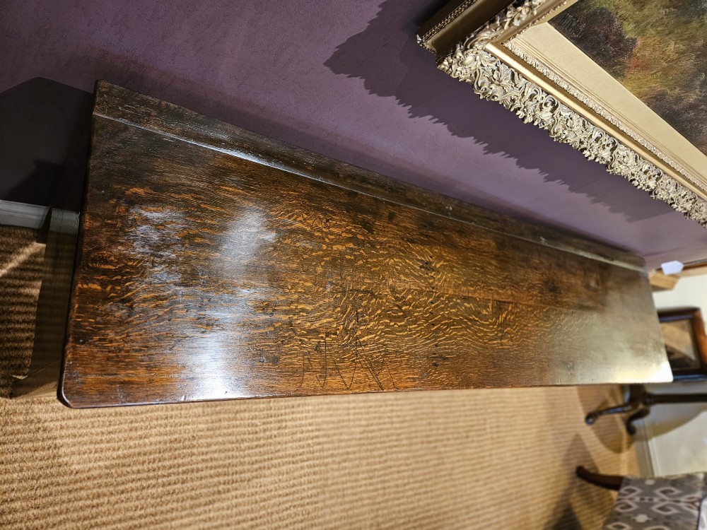 An eighteenth-century George III oak low dresser base featuring four drawers with brass swan-neck handles and a scalloped lower frieze. View VIII