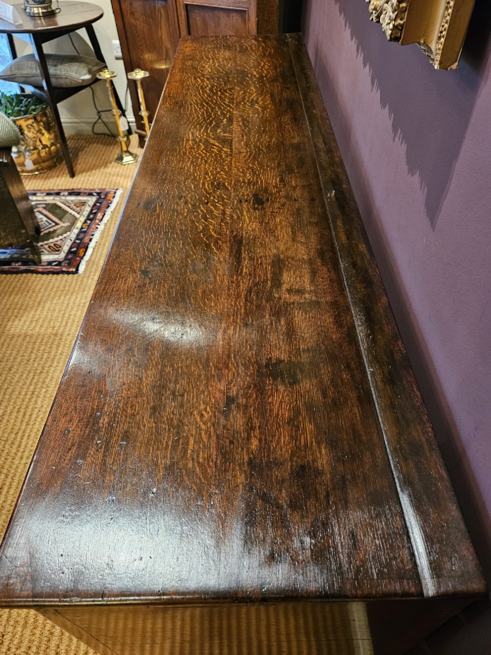An eighteenth-century George III oak low dresser base featuring four drawers with brass swan-neck handles and a scalloped lower frieze. View IX