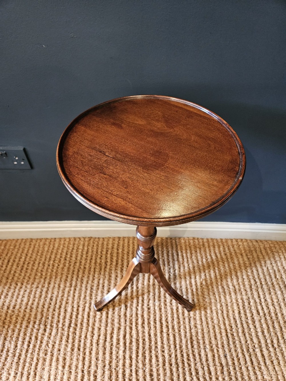 A George III mahogany wine table featuring a dished circular top, a turned central column, and a tripod base with three splayed legs. View II