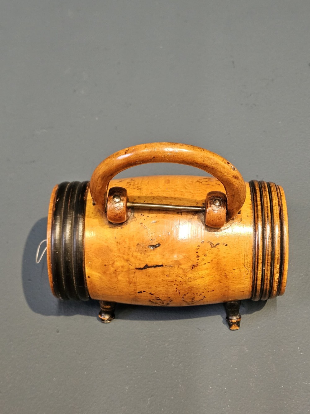 A turned Victorian fruitwood string barrel resting on four short turned feet with an arched top handle and dark ring details. View V