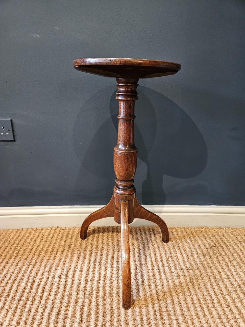A Regency oak candle table with a circular top, a turned central pedestal stem, and three splayed tripod legs. View III