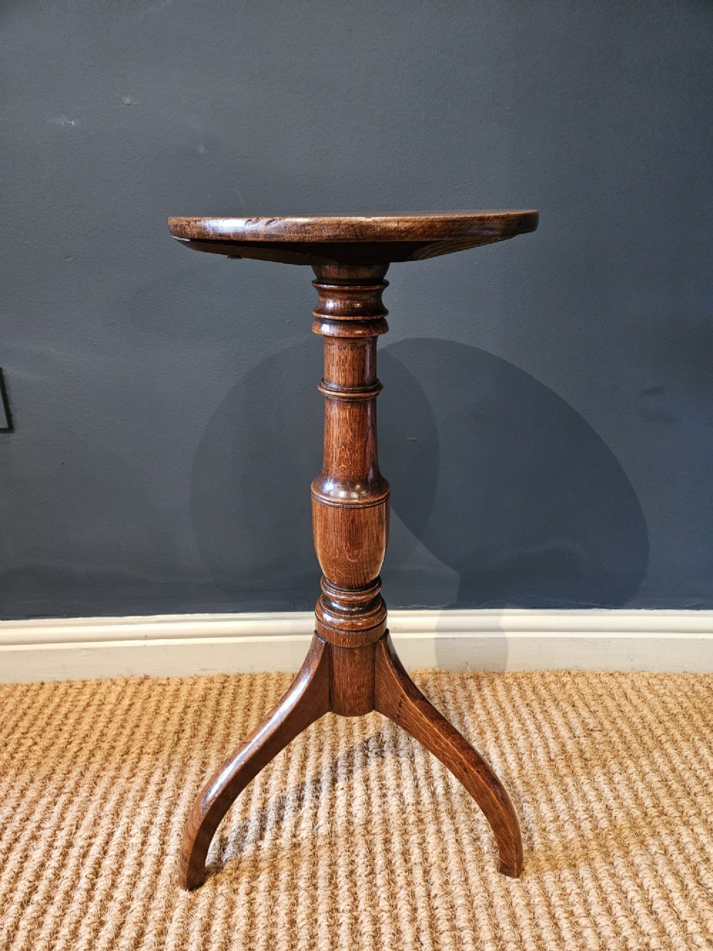 A Regency oak candle table with a circular top, a turned central pedestal stem, and three splayed tripod legs. View VI