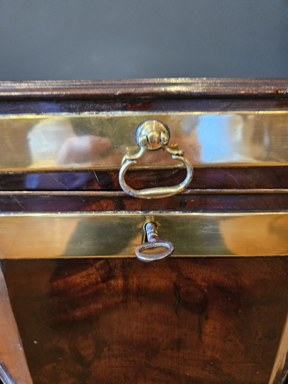 An octagonal George III mahogany wine cooler featuring brass binding bands, a hinged lid with starburst marquetry, and four square tapered legs. View II