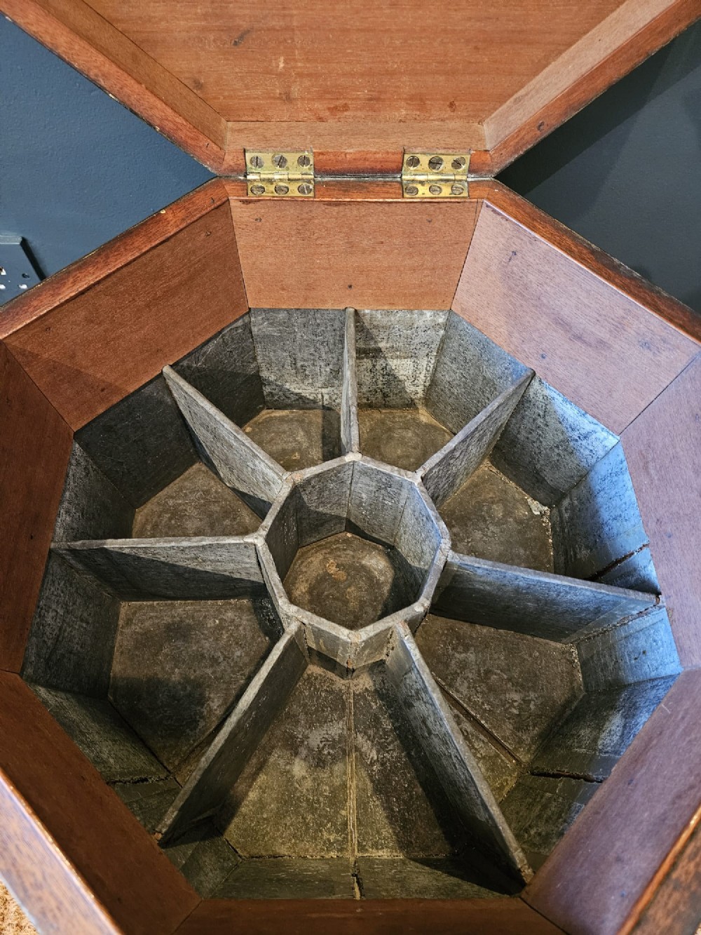 An octagonal George III mahogany wine cooler featuring brass binding bands, a hinged lid with starburst marquetry, and four square tapered legs. View VII