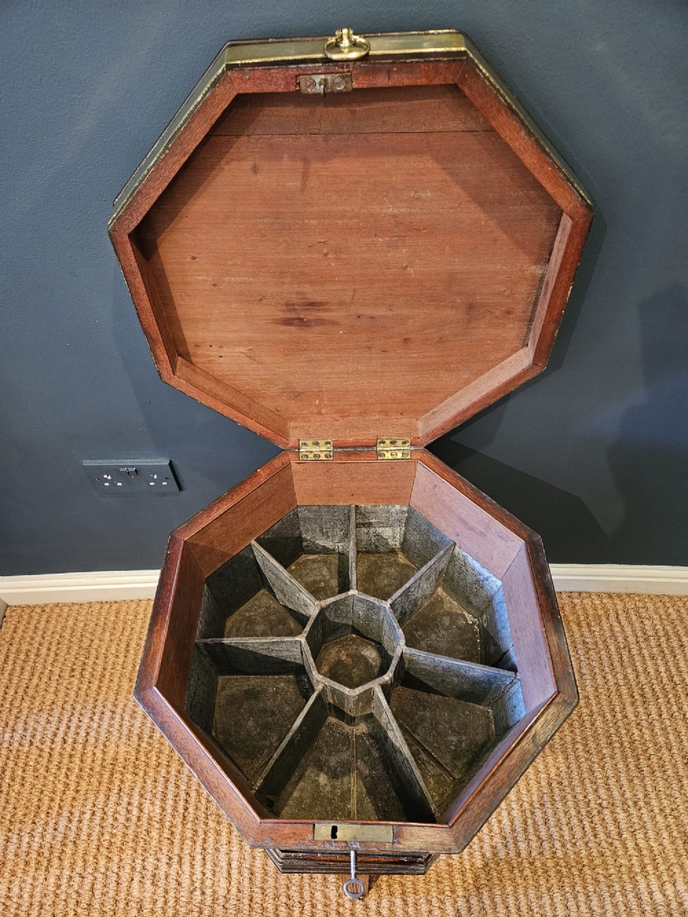 An octagonal George III mahogany wine cooler featuring brass binding bands, a hinged lid with starburst marquetry, and four square tapered legs. View VIII