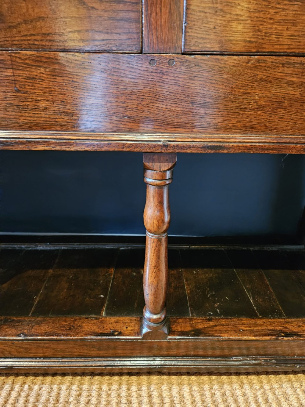 An 18th-century George II oak pot board dresser featuring three frieze drawers with brass handles set above an open lower shelf and turned baluster supports. View VI