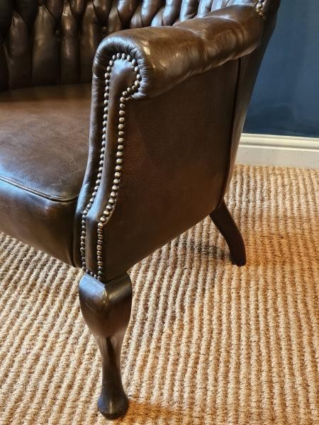 A Victorian dark brown leather armchair featuring deep button tufting, brass stud trimming, and cabriole front legs. View III