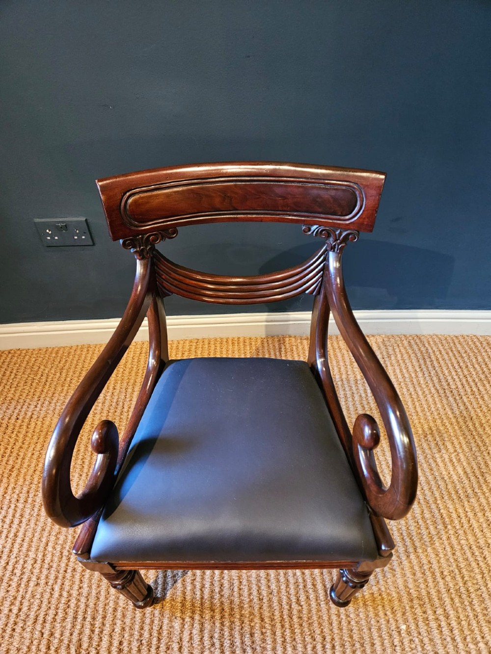 A 19th-century William IV dark mahogany desk chair featuring dynamic scroll arms, turned reeded front legs, and a black leather upholstered seat. View VIII