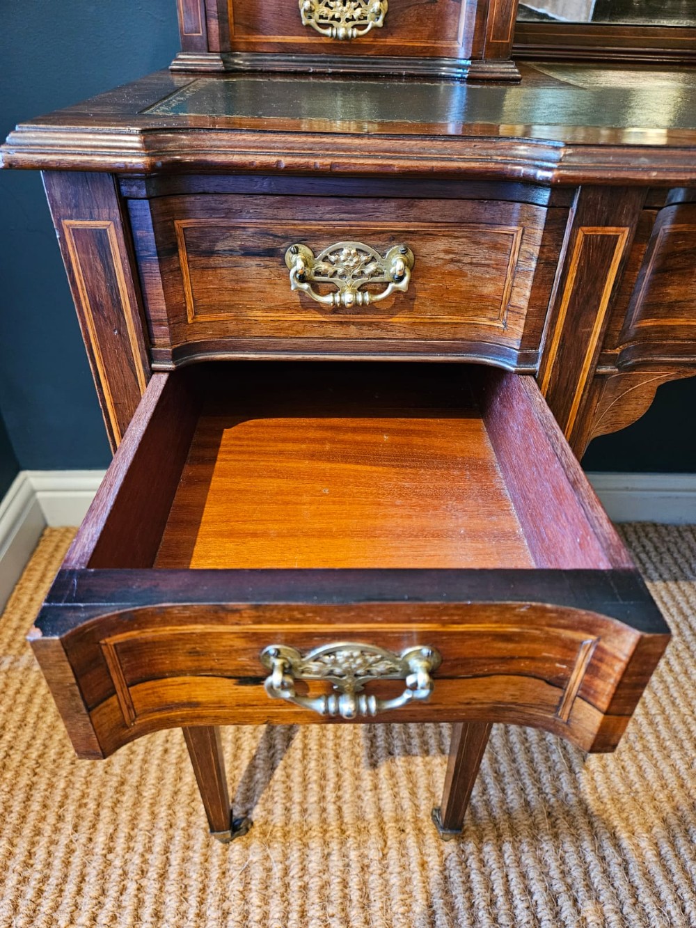 An Edwardian inlaid rosewood writing desk featuring a central green leather writing surface, raised side drawers, and tapered square legs. View III