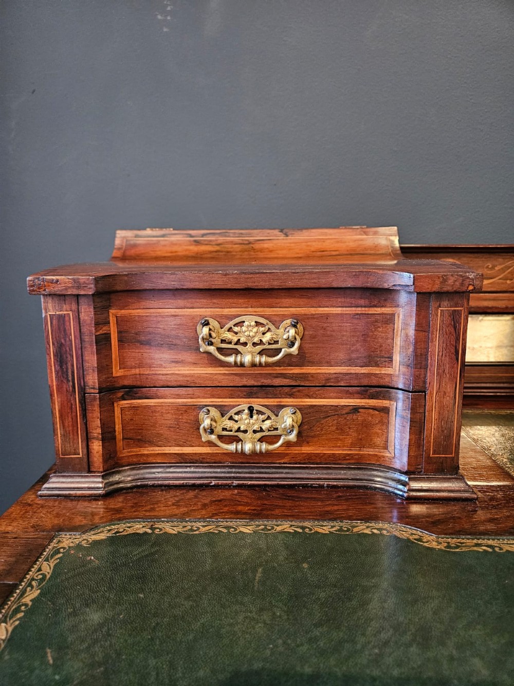 An Edwardian inlaid rosewood writing desk featuring a central green leather writing surface, raised side drawers, and tapered square legs. View IV