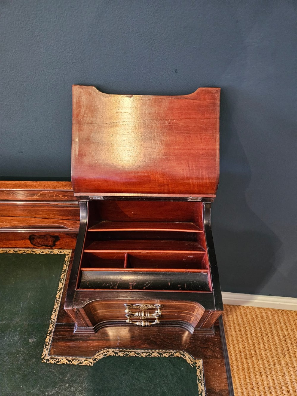 An Edwardian inlaid rosewood writing desk featuring a central green leather writing surface, raised side drawers, and tapered square legs. View VI
