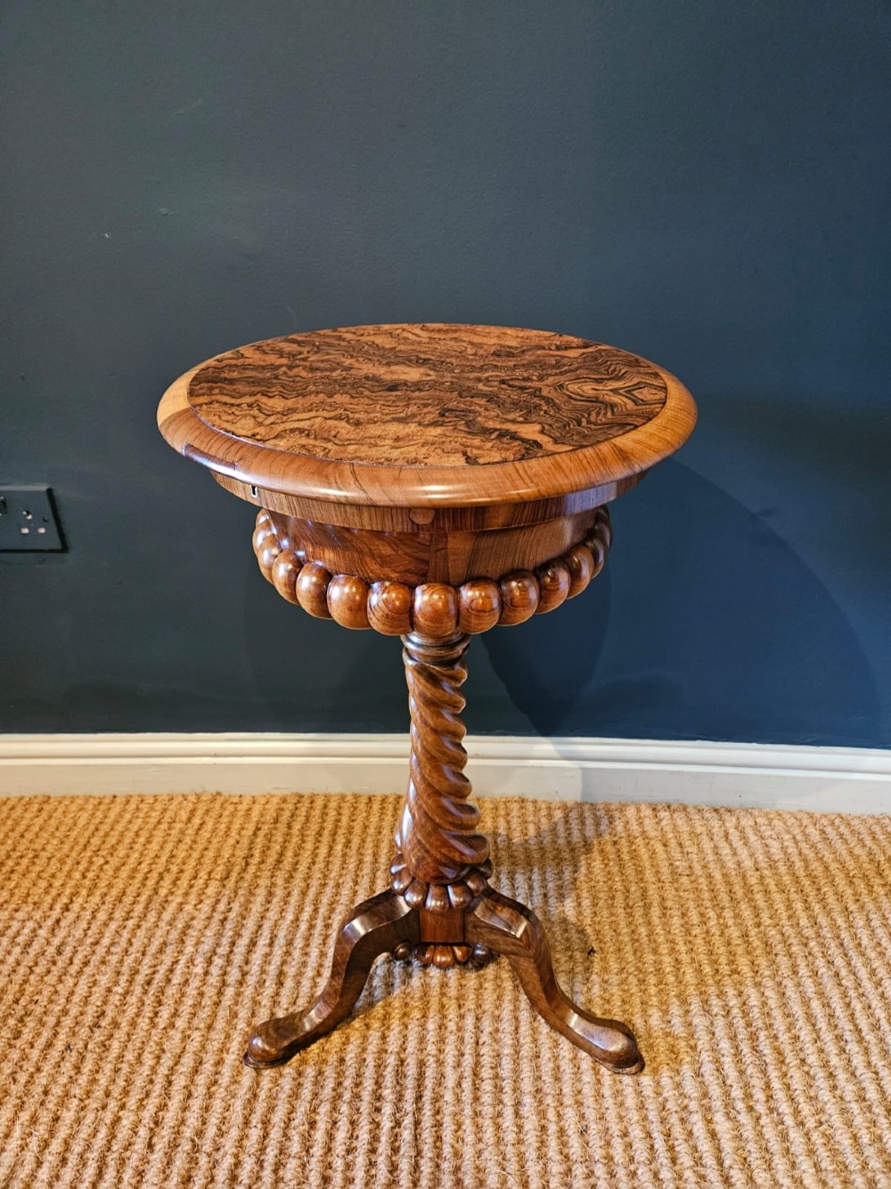 An early Victorian circular burr walnut work table featuring a spiral-turned column, beaded rim moulding, and a tripod cabriole base.
