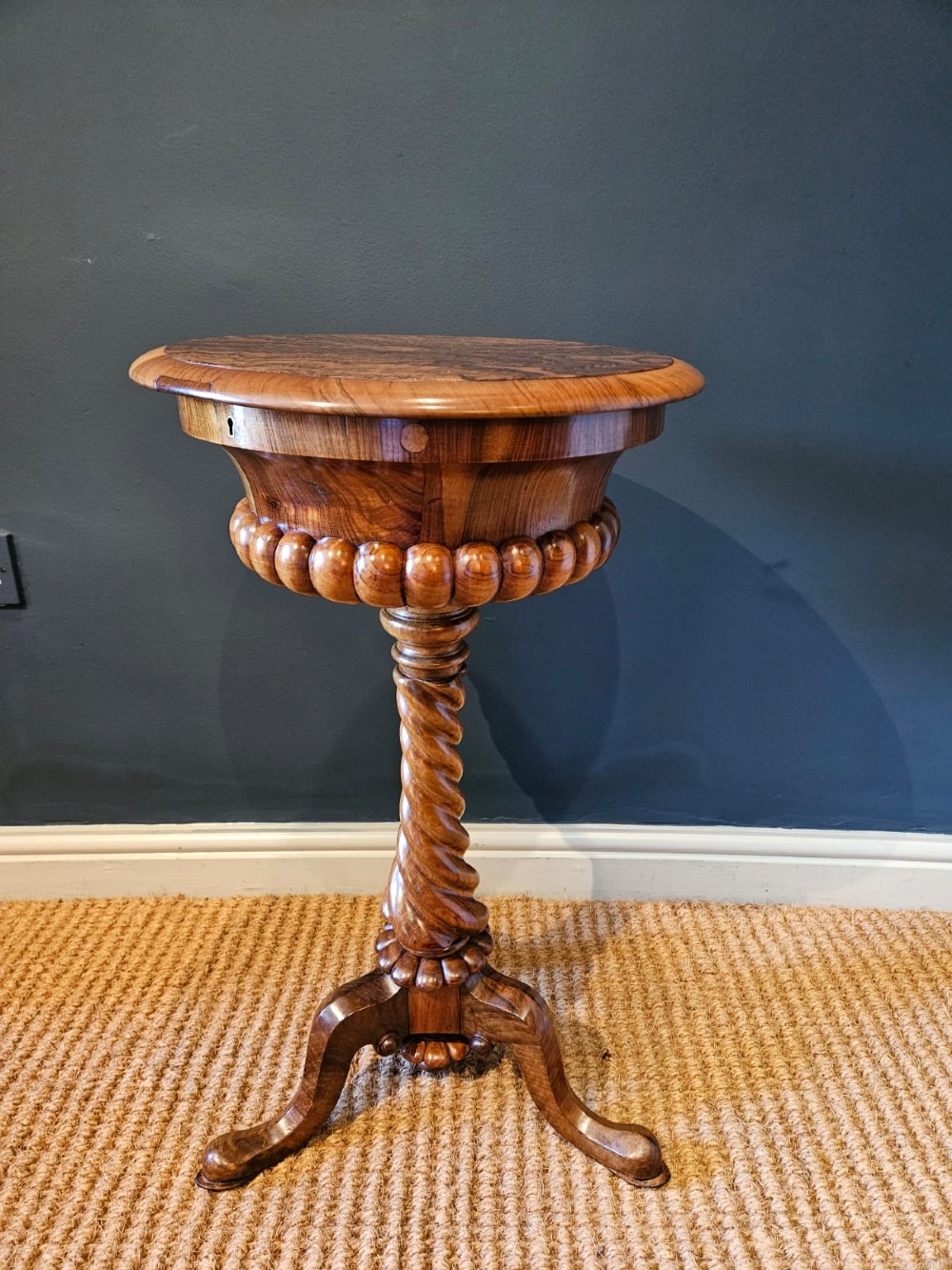 An early Victorian circular burr walnut work table featuring a spiral-turned column, beaded rim moulding, and a tripod cabriole base. View II