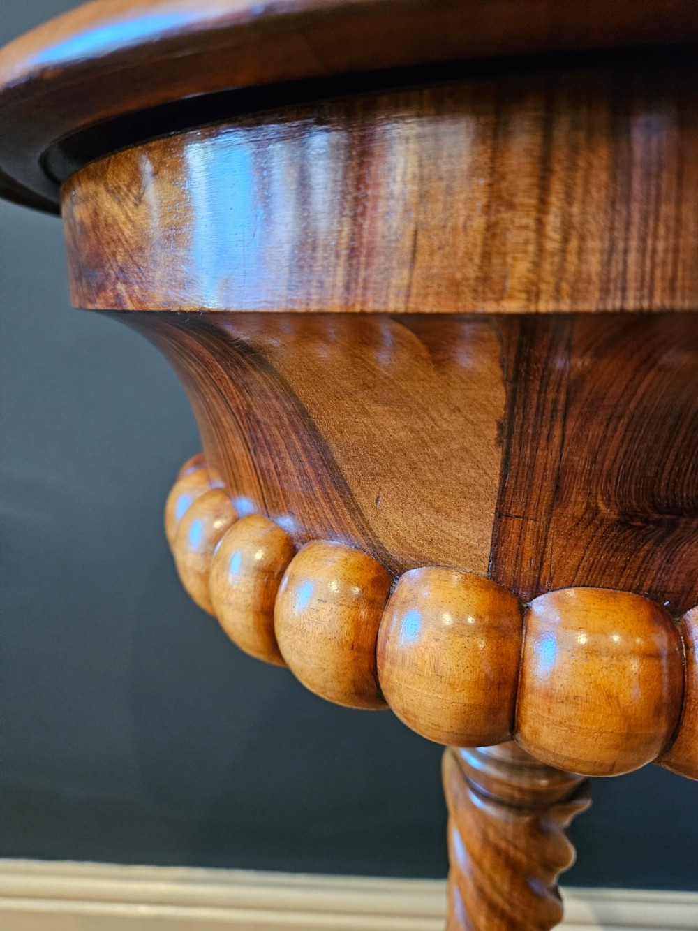 An early Victorian circular burr walnut work table featuring a spiral-turned column, beaded rim moulding, and a tripod cabriole base. View III
