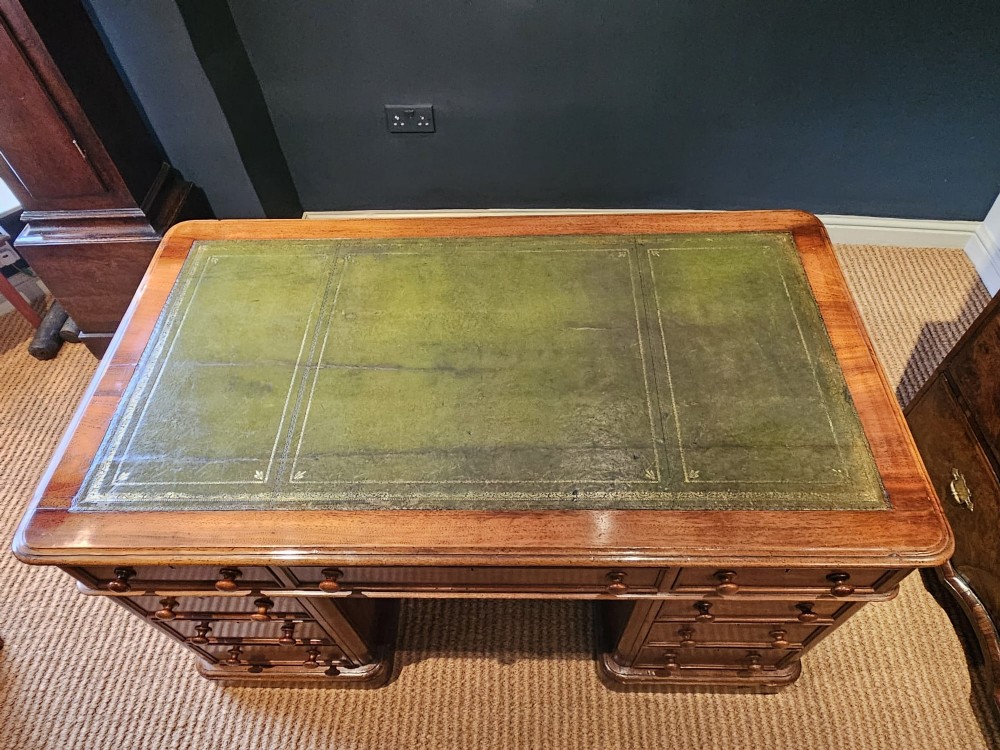 A Mid-Victorian mahogany partners desk featuring a pedestal layout with nine drawers on the front, turned timber knobs, and a solid plinth base. View II