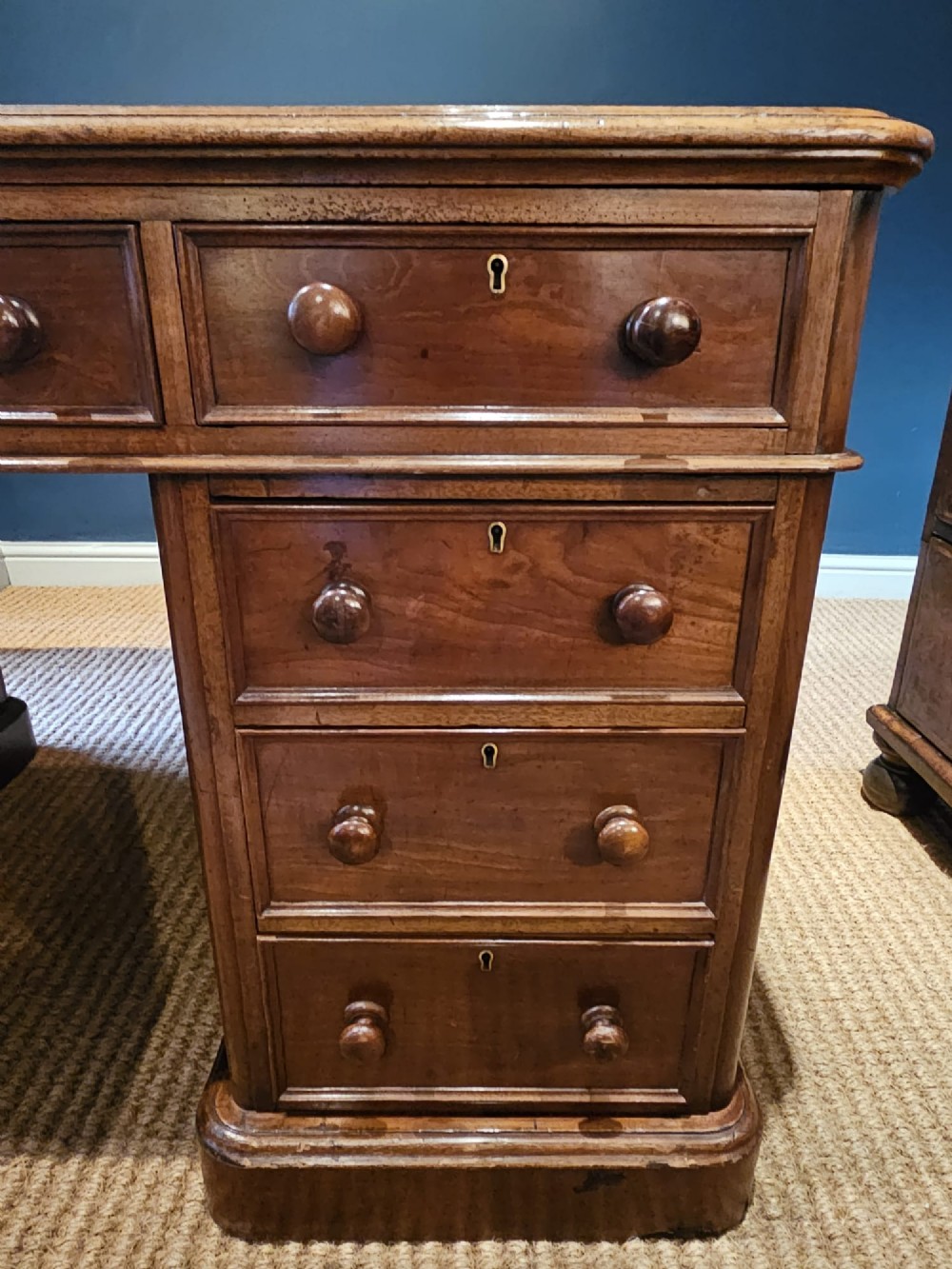A Mid-Victorian mahogany partners desk featuring a pedestal layout with nine drawers on the front, turned timber knobs, and a solid plinth base. View III