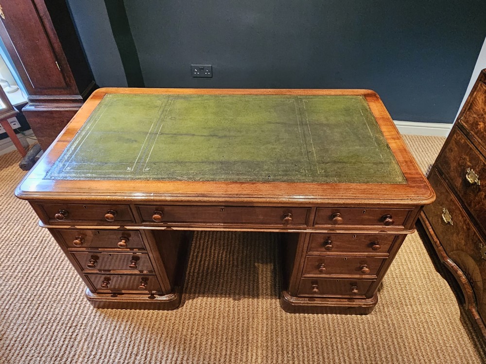A Mid-Victorian mahogany partners desk featuring a pedestal layout with nine drawers on the front, turned timber knobs, and a solid plinth base. View IV