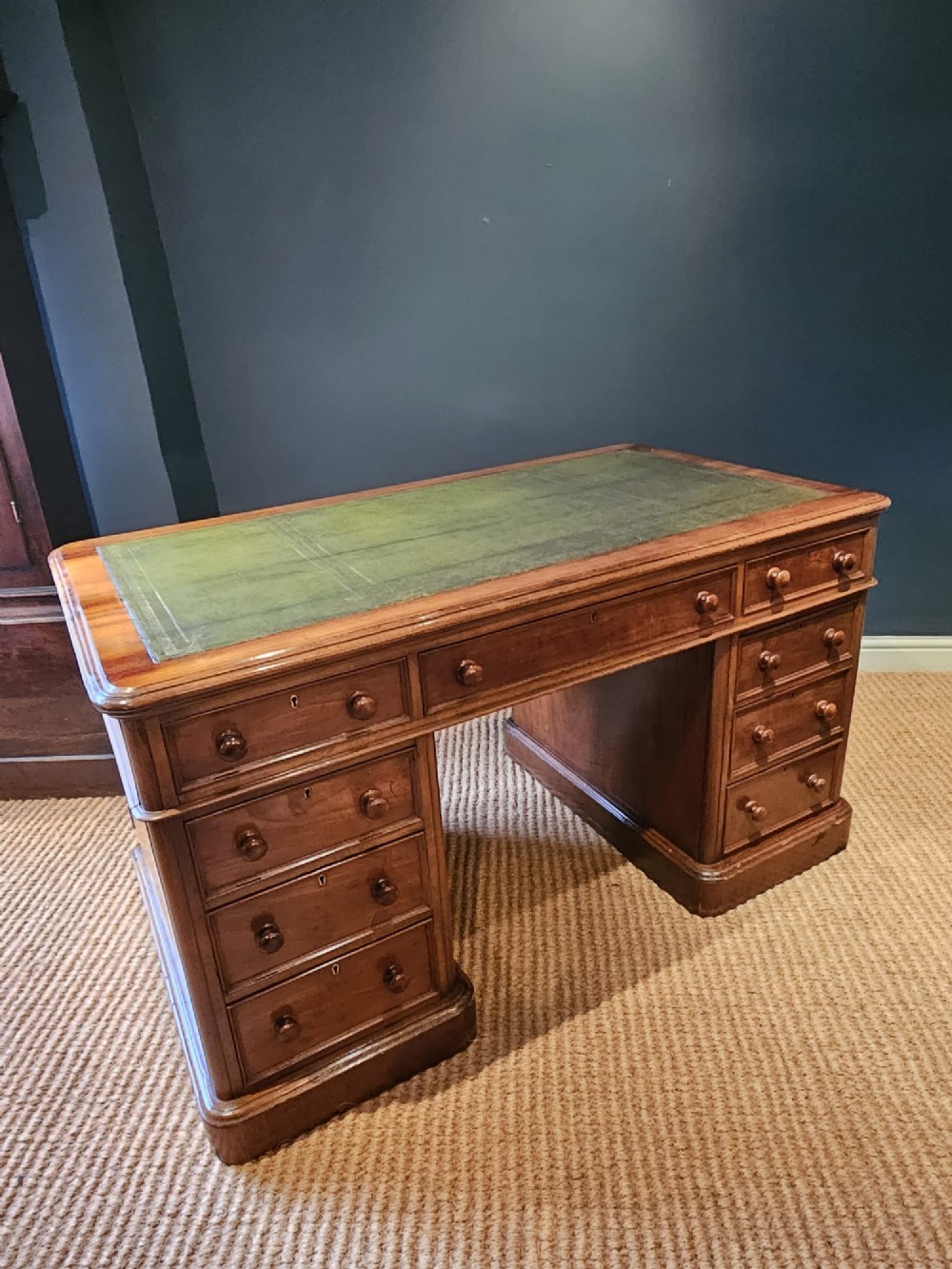 A Mid-Victorian mahogany partners desk featuring a pedestal layout with nine drawers on the front, turned timber knobs, and a solid plinth base. View VIII