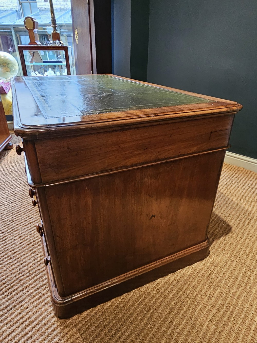 A Mid-Victorian mahogany partners desk featuring a pedestal layout with nine drawers on the front, turned timber knobs, and a solid plinth base. View XII