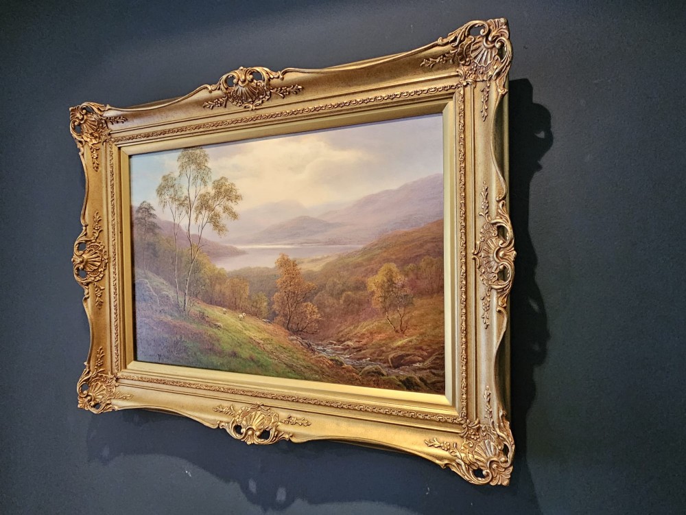 A Victorian landscape oil painting depicting a Lake District scene with hills and trees, enclosed in an ornate gold gilt frame. View III