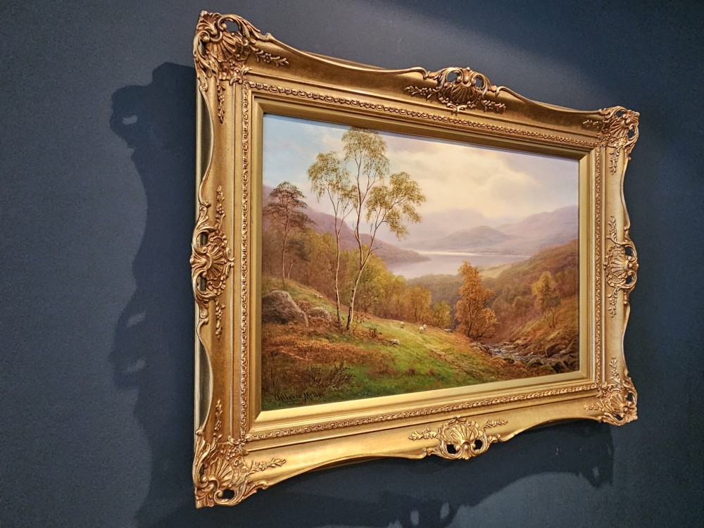 A Victorian landscape oil painting depicting a Lake District scene with hills and trees, enclosed in an ornate gold gilt frame. View V