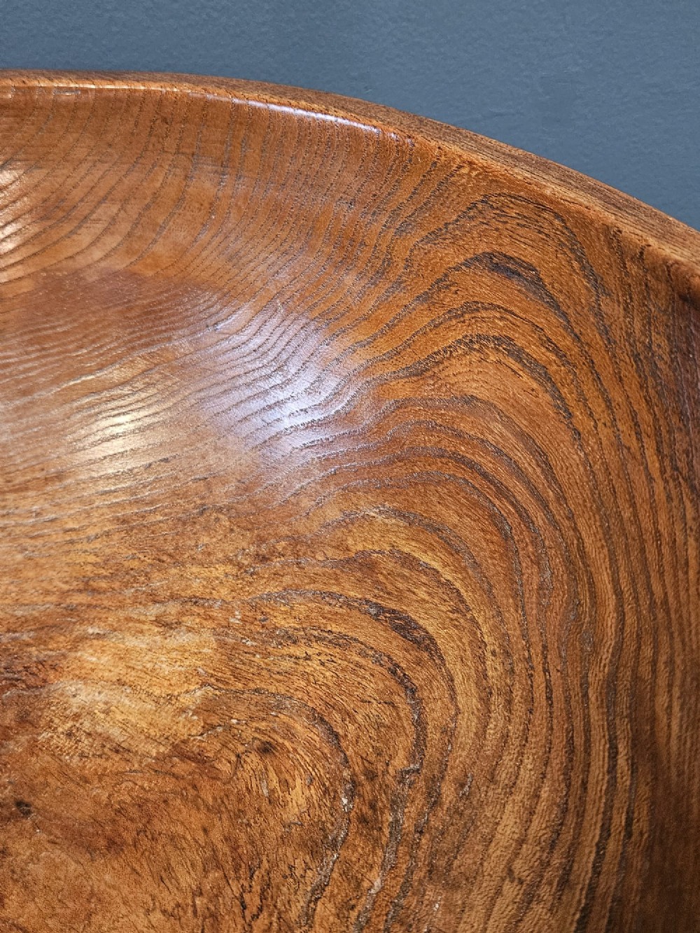 A turned early Victorian warm brown elm wood dairy bowl with a wide curved rim showing natural wood grain. View VI