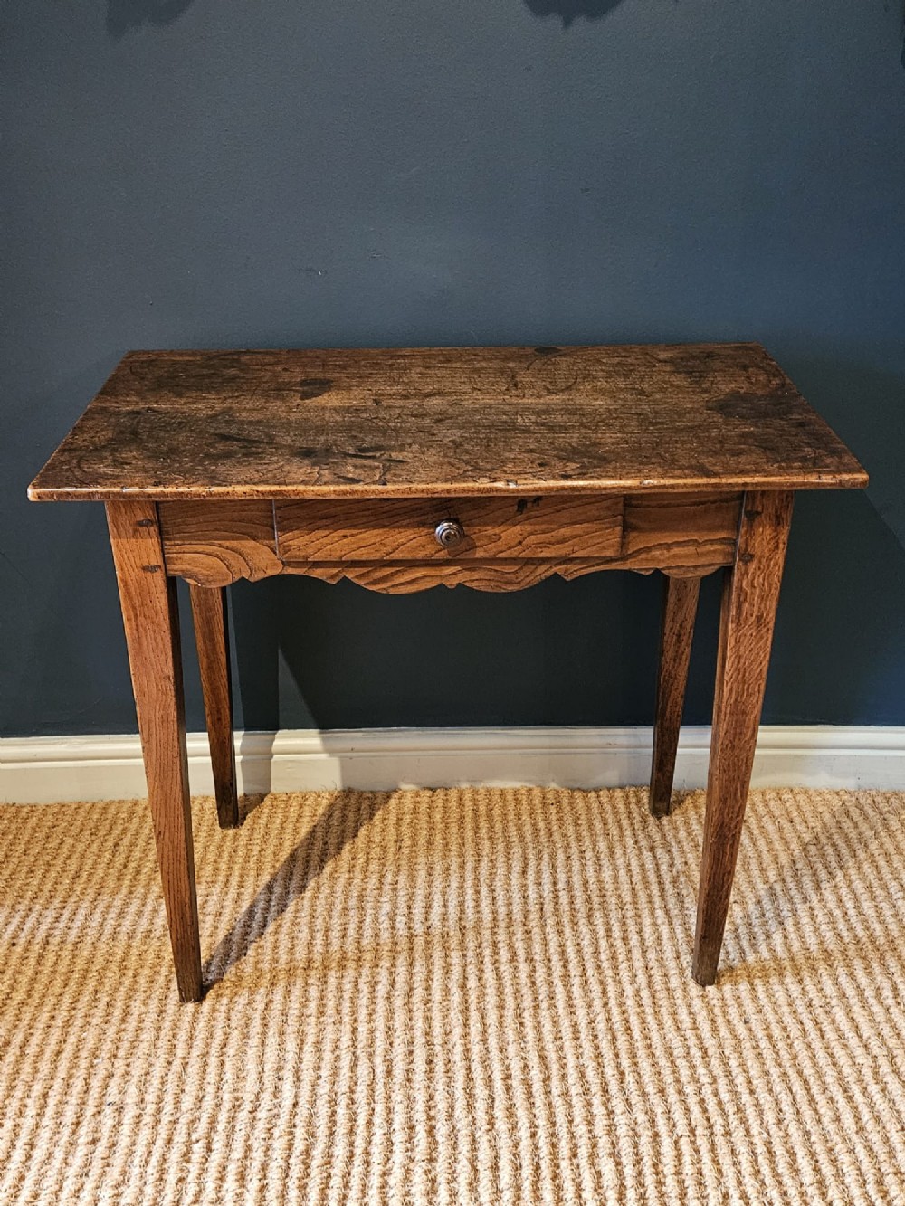 A George III elm single drawer side table featuring a rectangular top, a shaped apron, a turned wooden drawer knob, and tapered square legs. View II