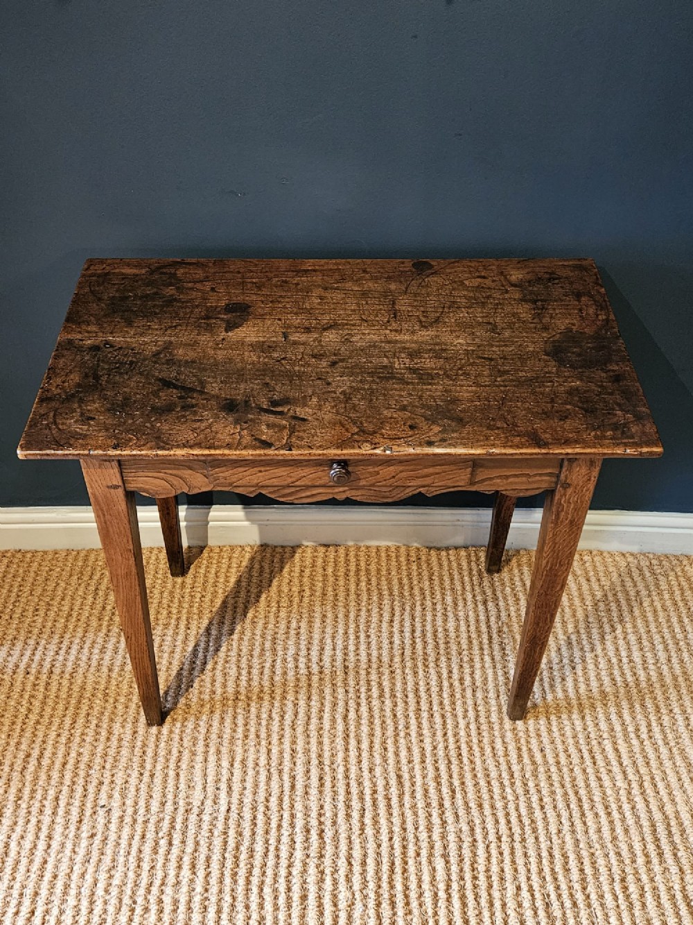 A George III elm single drawer side table featuring a rectangular top, a shaped apron, a turned wooden drawer knob, and tapered square legs. View V