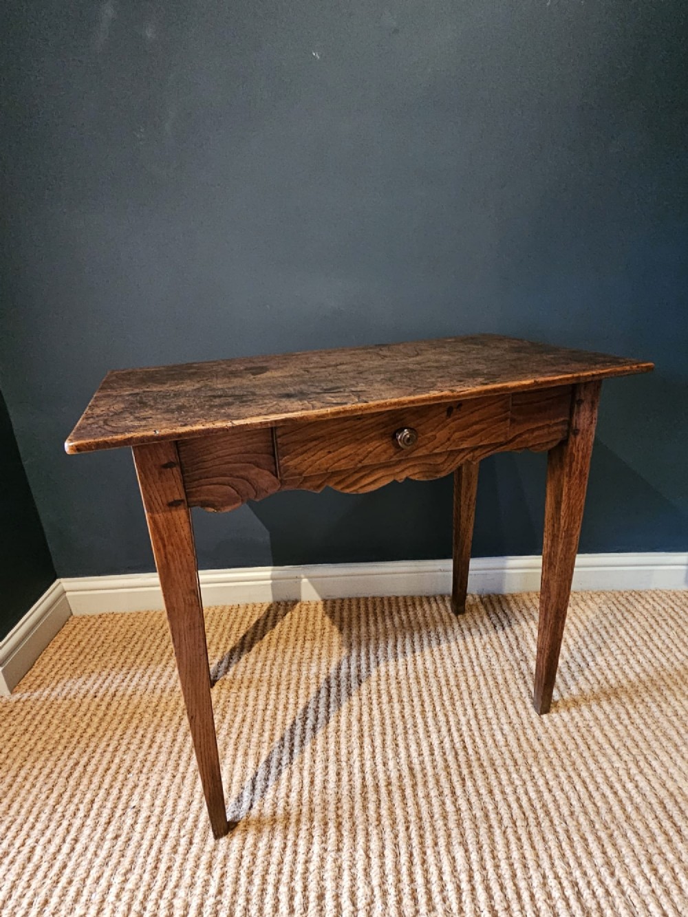 A George III elm single drawer side table featuring a rectangular top, a shaped apron, a turned wooden drawer knob, and tapered square legs. View IX