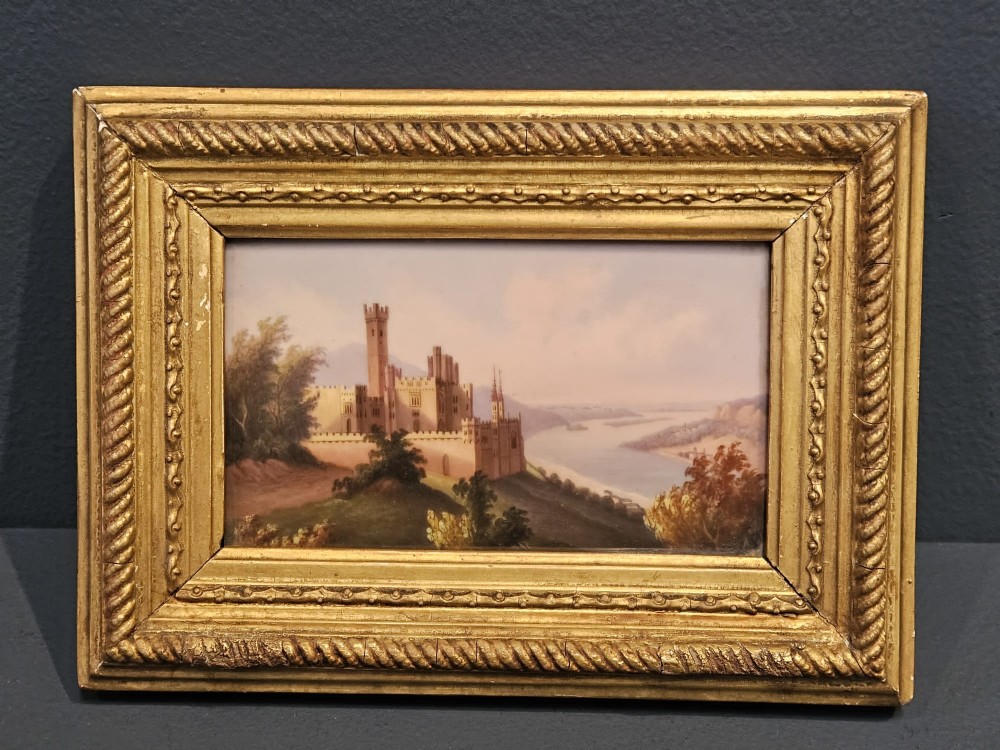 A pair of rectangular Victorian hand-painted porcelain plaques depicting European landscape scenes set within ornate giltwood rope-twist frames. View III