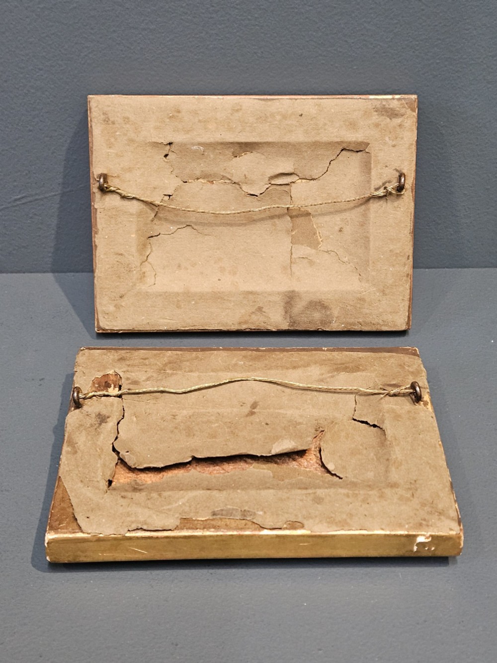 A pair of rectangular Victorian hand-painted porcelain plaques depicting European landscape scenes set within ornate giltwood rope-twist frames. View VI