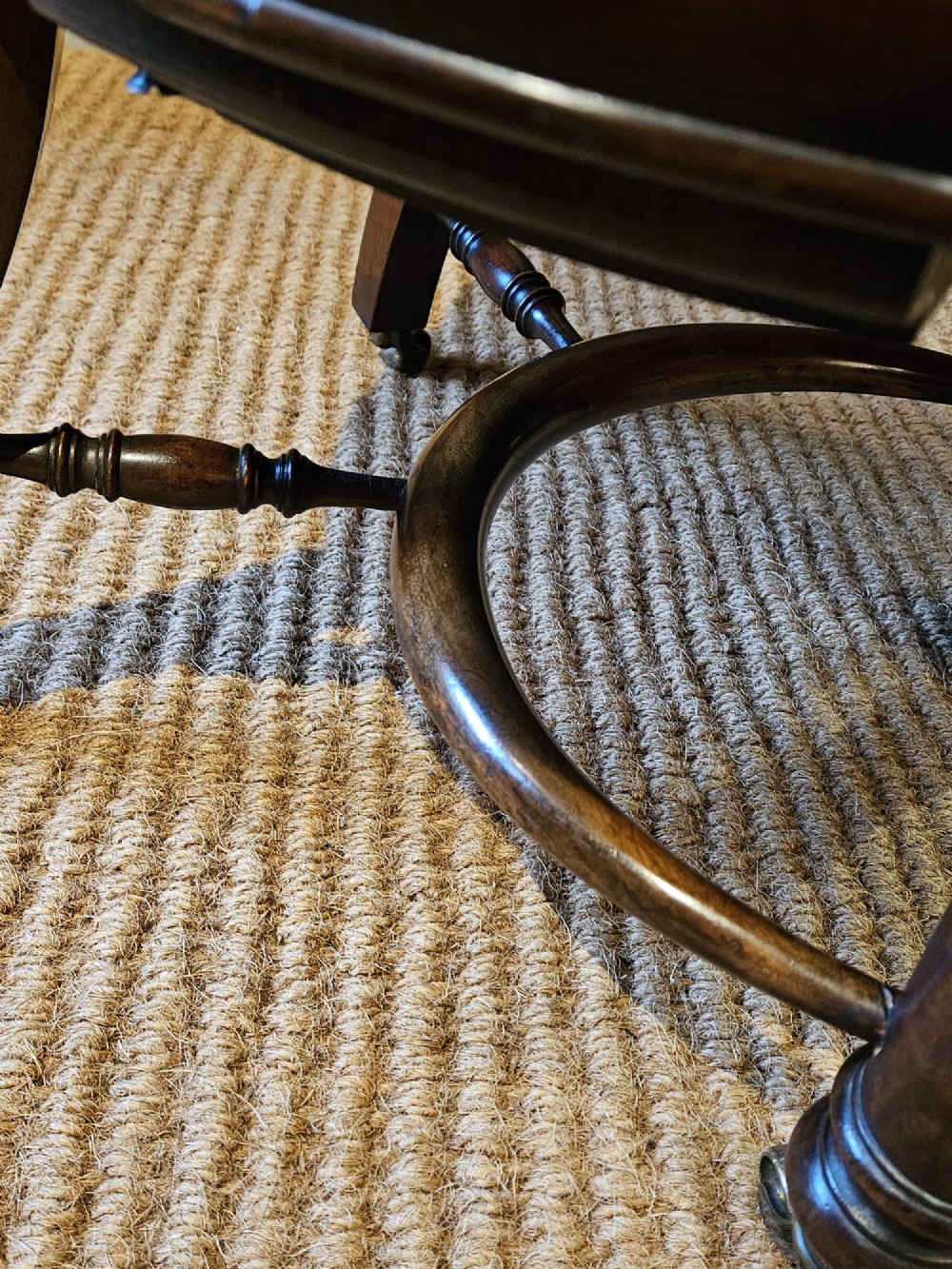 A Victorian revolving desk chair upholstered in tan hide leather with brass stud trim, curved armrests, and turned mahogany legs on brass castors. View VIII